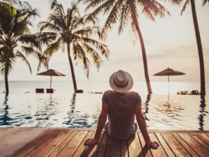 Man looking out onto the pool and beach